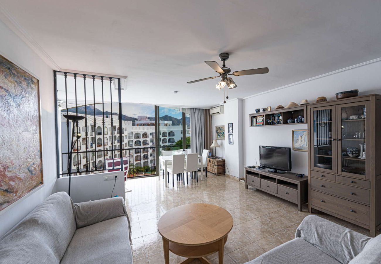 Lichte woonkamer met bank en tv in vakantieappartement voor 4 personen in Nerja