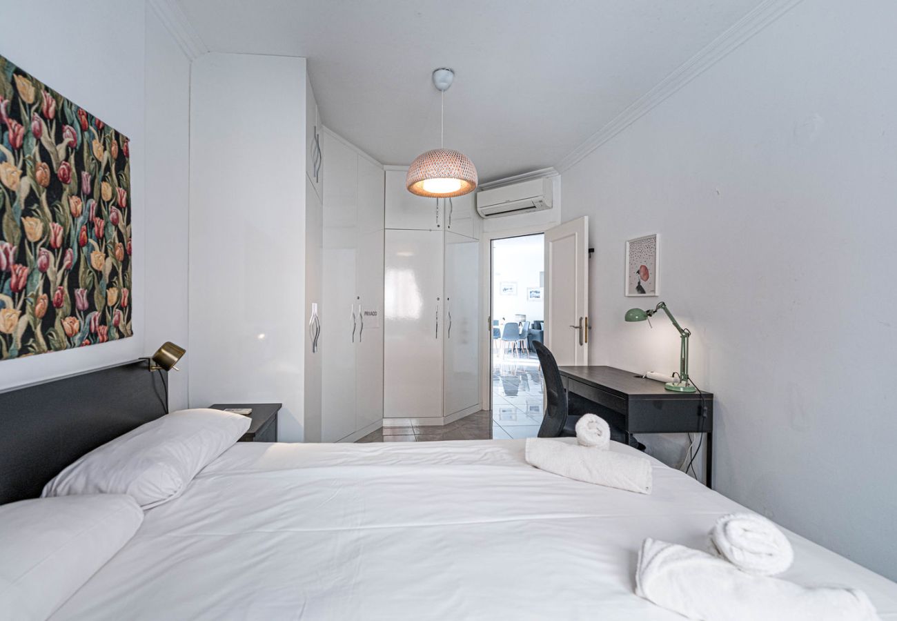 Slaapkamer met tweepersoonsbed en werkplek voor telewerken in Nerja.