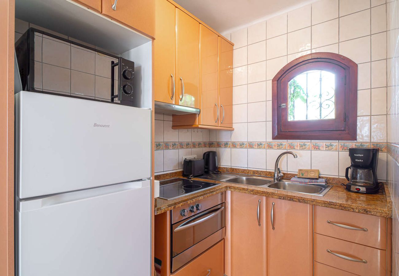 Volledig uitgeruste open keuken met oven, magnetron en moderne apparatuur.