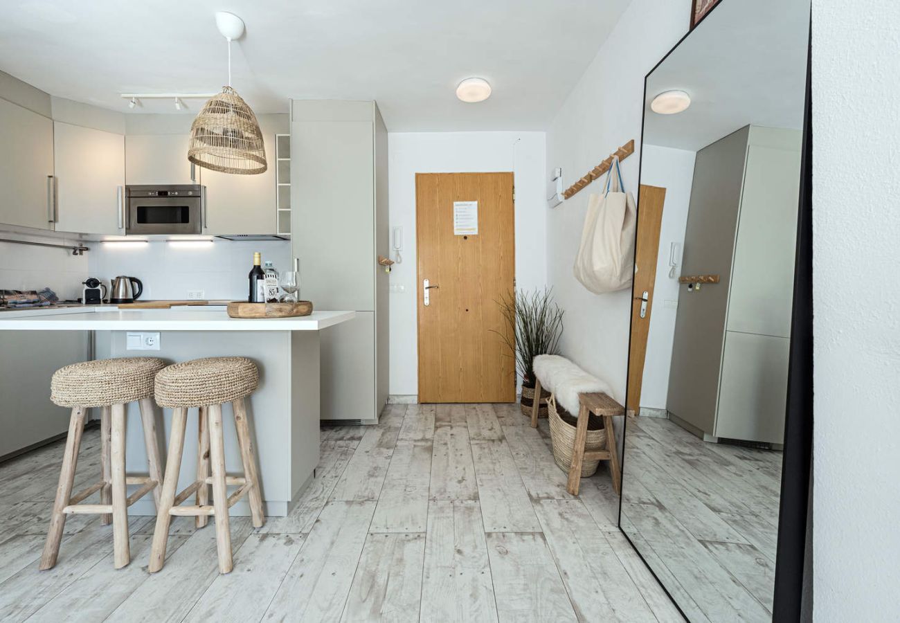 Lichte woonkamer van appartement Acapulco Playa 302 met directe toegang tot het terras.