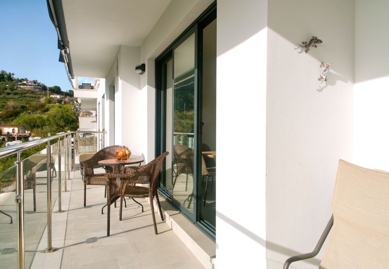 Privéterras met zeezicht in Nerja voorzien van buitenmeubilair en middagzon.