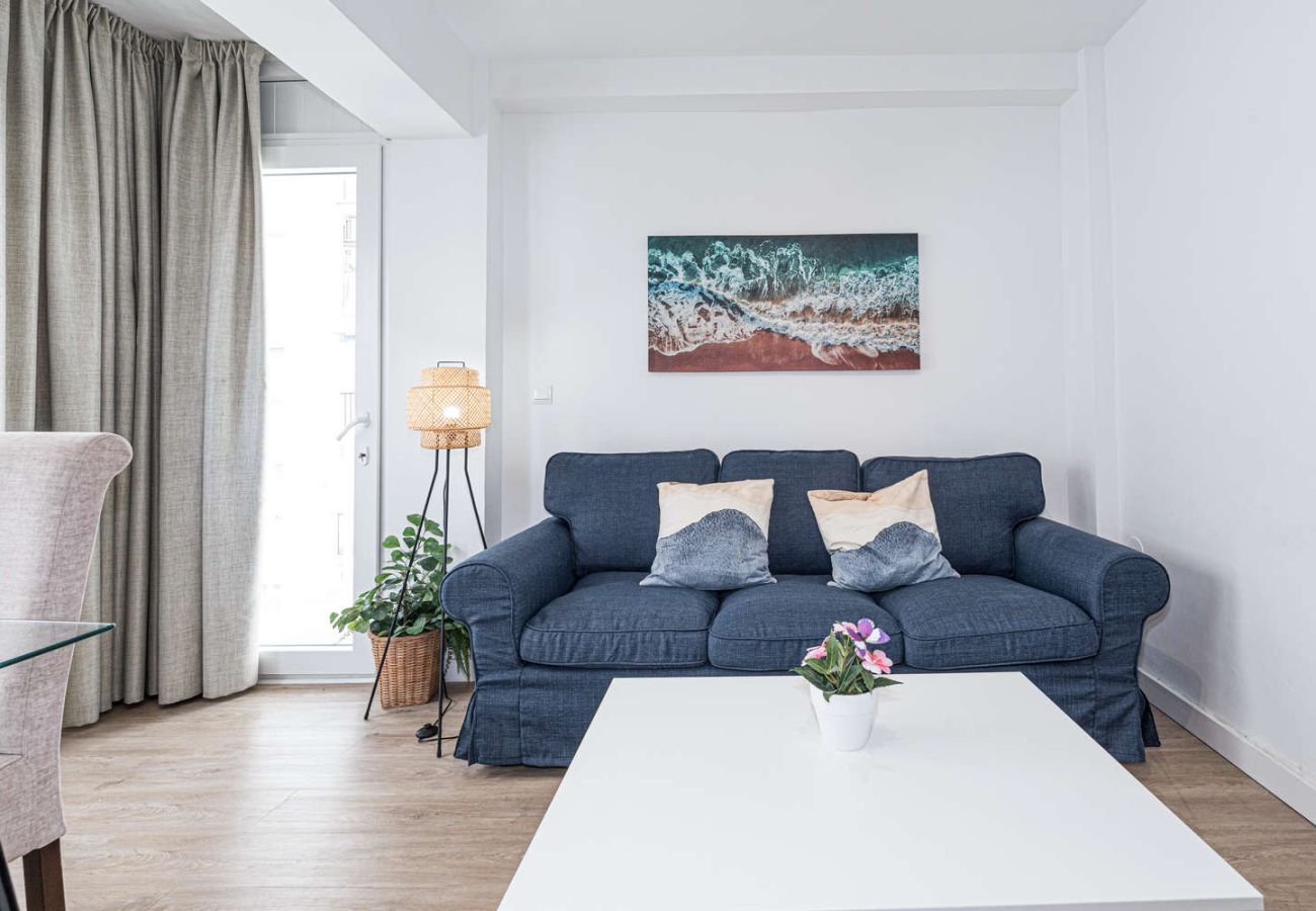 Gezellige woonkamer met comfortabele bank en veel natuurlijk licht nabij het strand in Nerja.