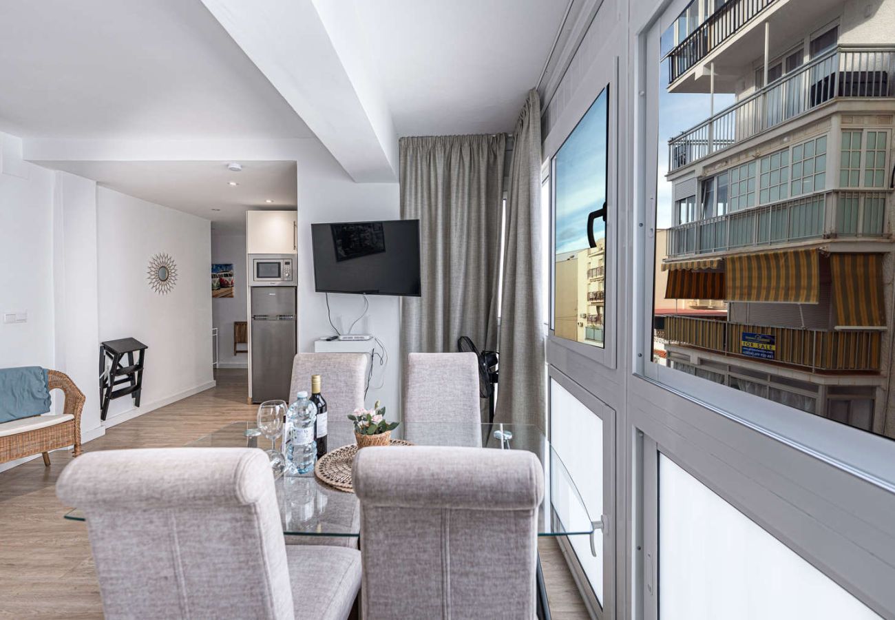 Eethoek met glazen tafel naast een groot licht raam in Nerja.