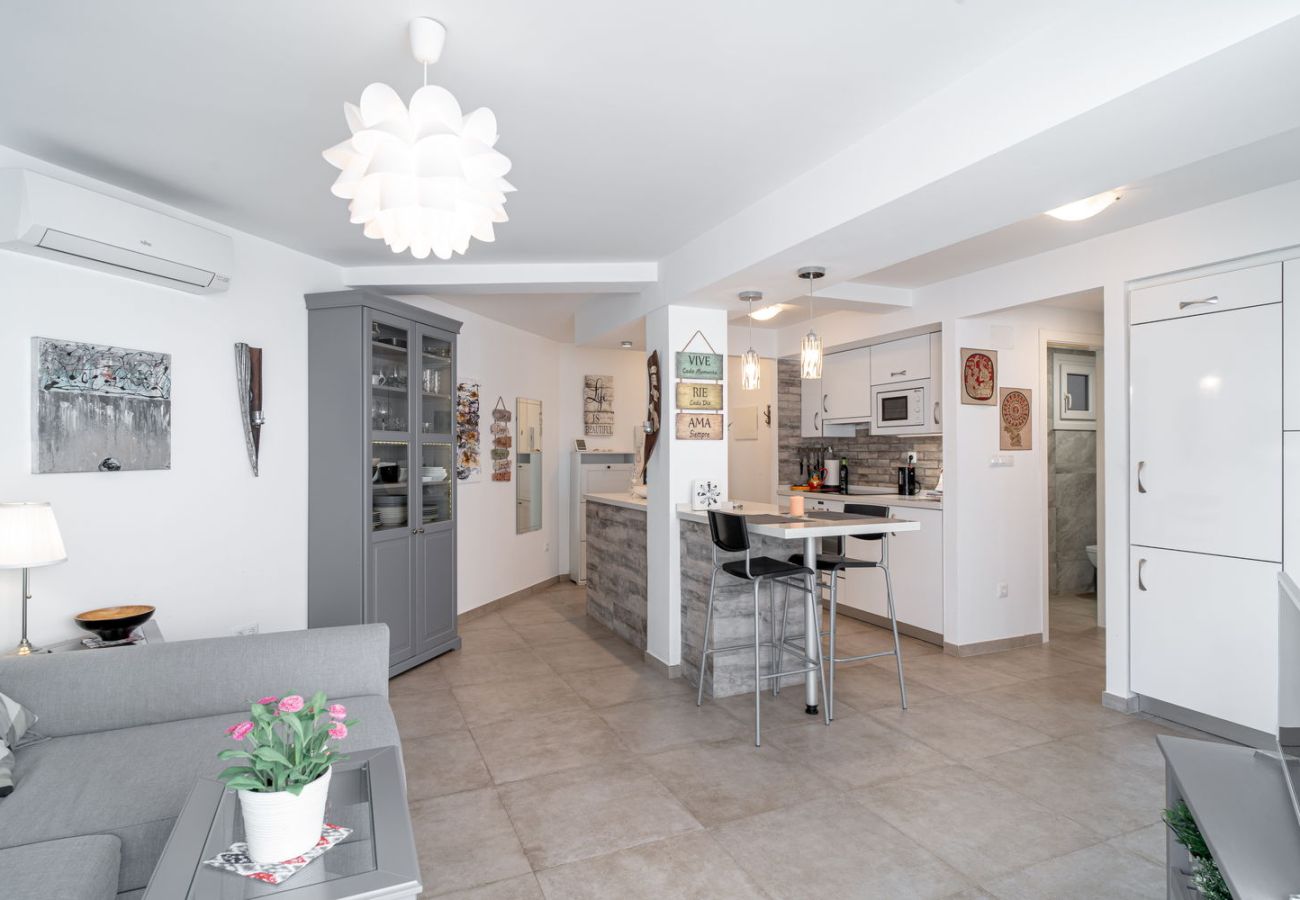 Overzicht van de moderne open woonkamer en keuken in het centrum van Nerja.