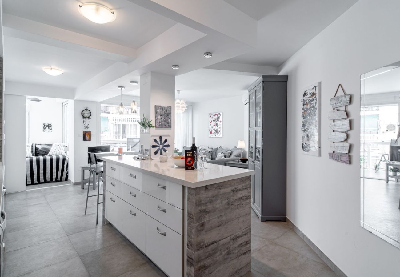 Eethoek met houten tafel en designstoelen naast de uitgeruste keuken in Nerja.