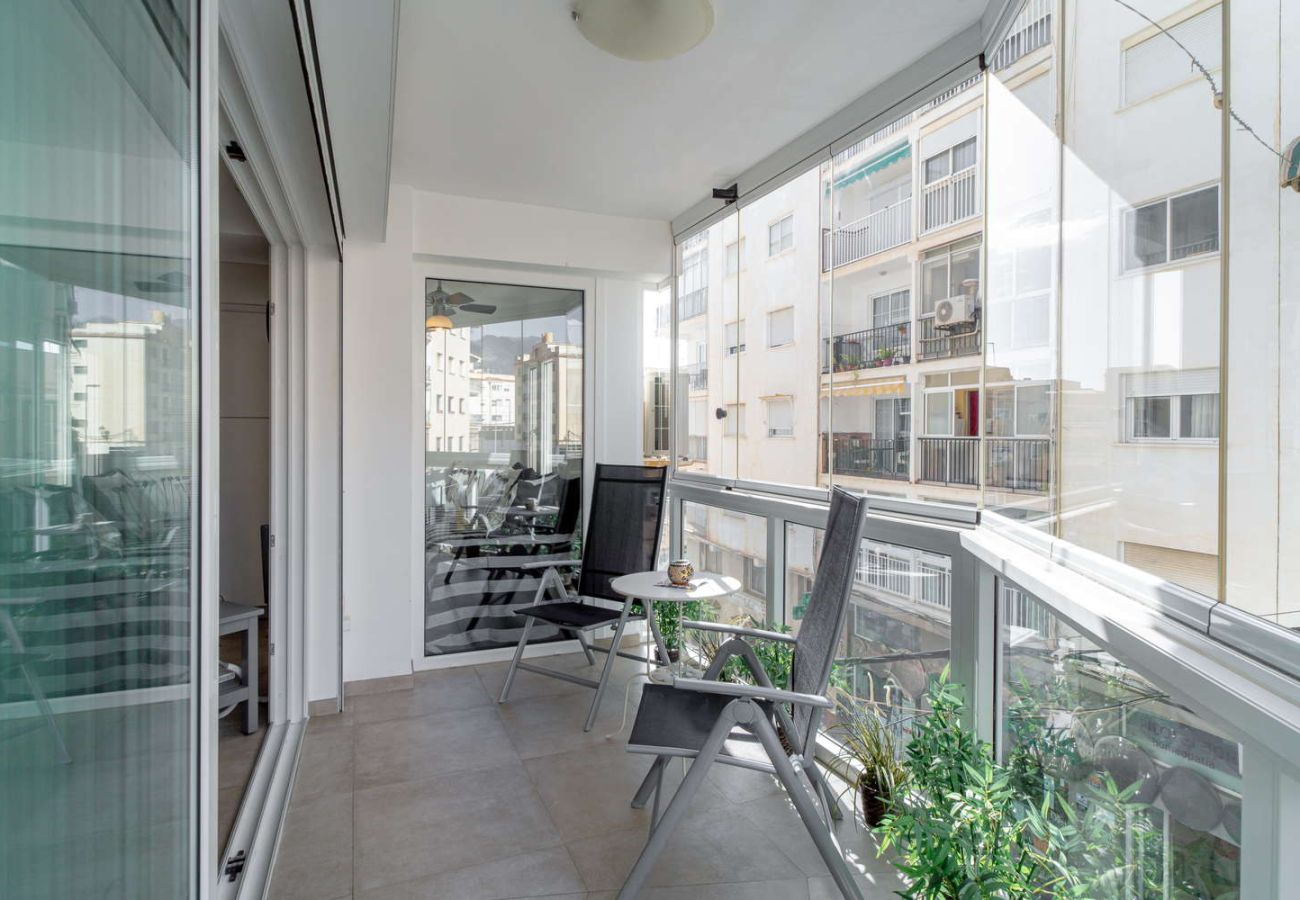 Ingesloten glazen balkon met zithoek voor het ontbijt in Nerja centrum.