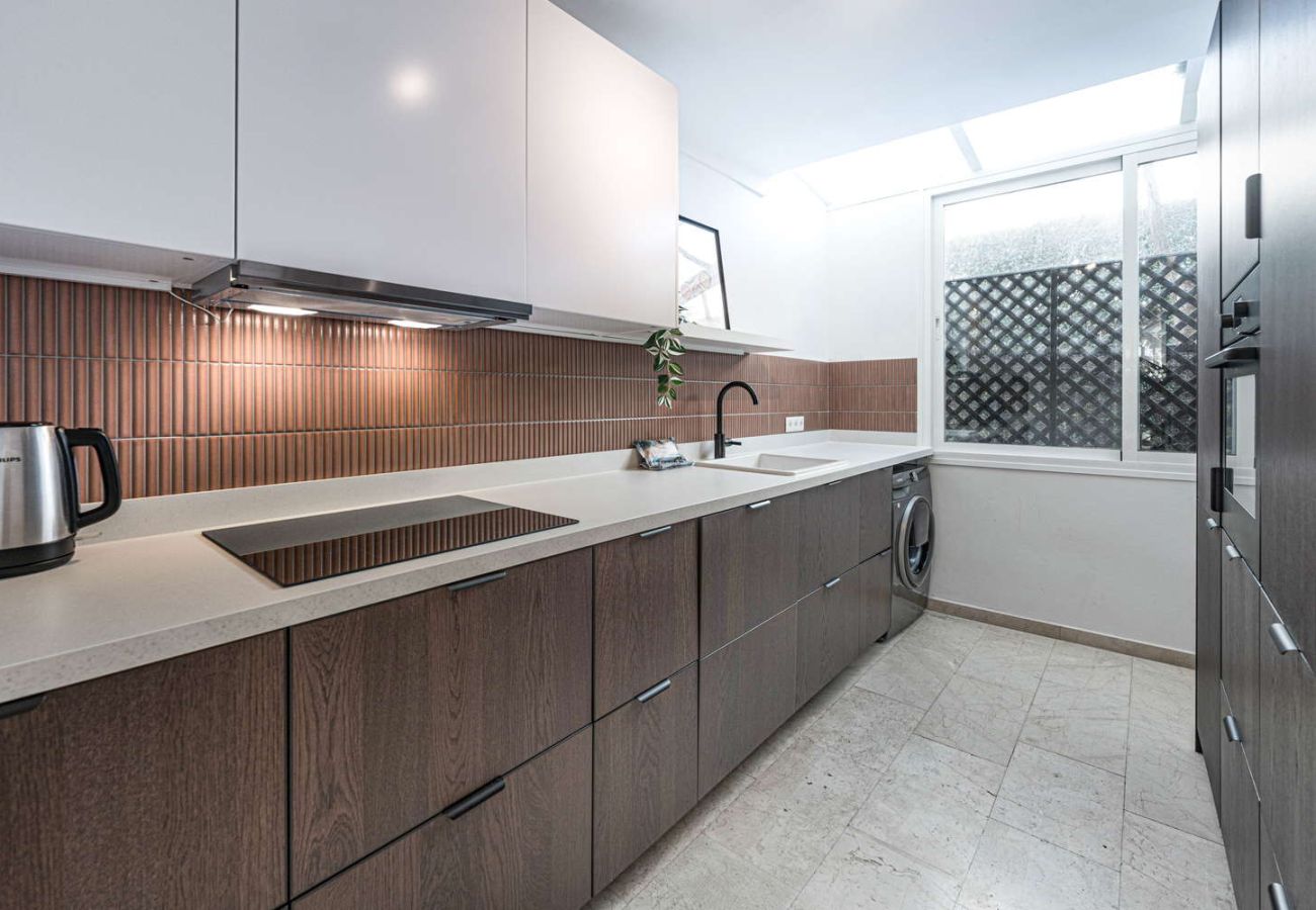 Volledig uitgeruste moderne keuken met oven, magnetron en elegant design in vakantieaccommodatie.