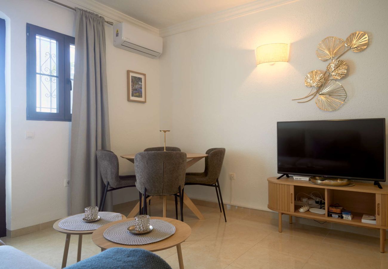 Licht interieur van de woon- en eetkamer met toegang tot het terras in Capistrano Village Nerja.