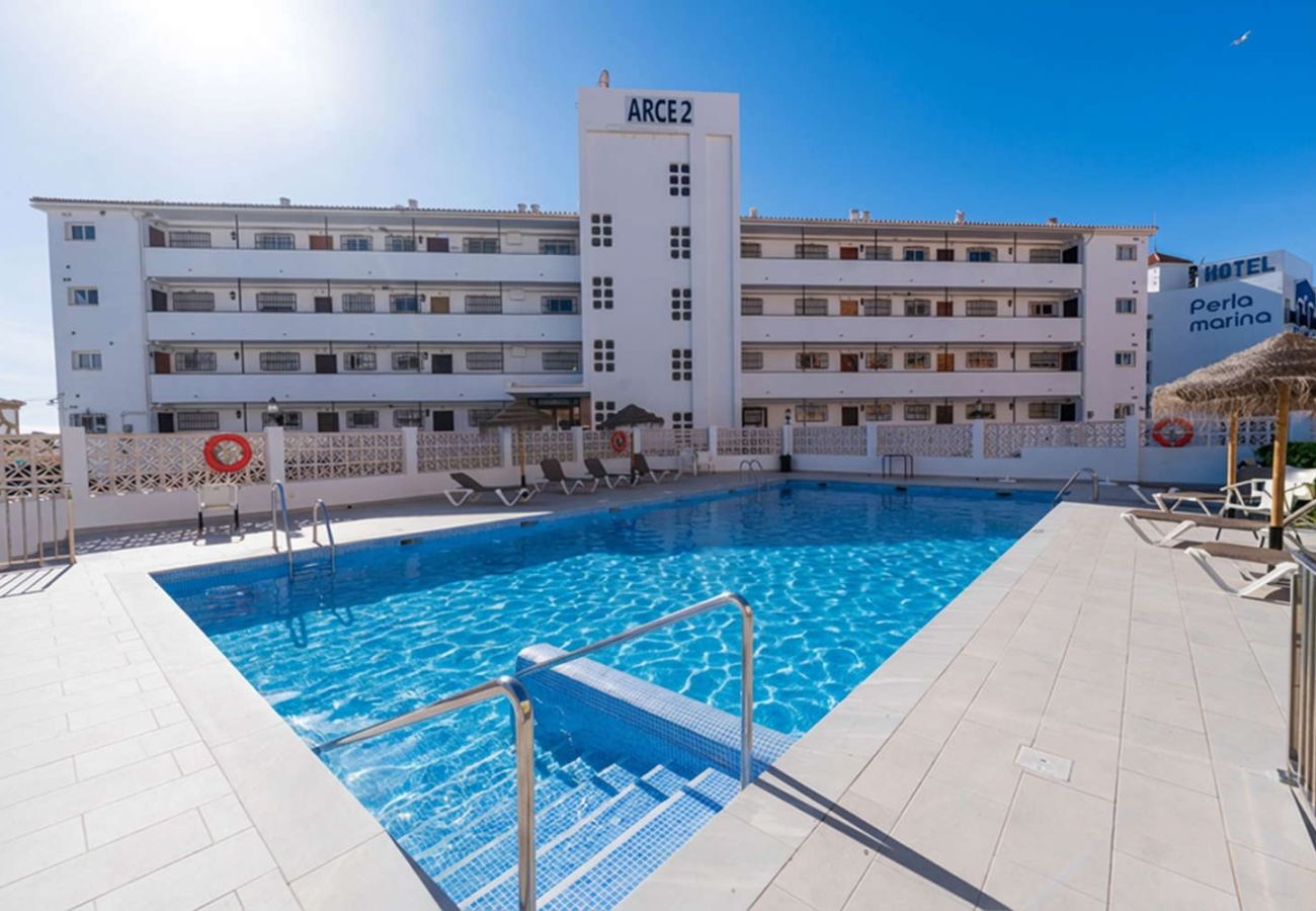 Gemeenschappelijk zwembad met ligbedden bij het Arce II-gebouw in Nerja.