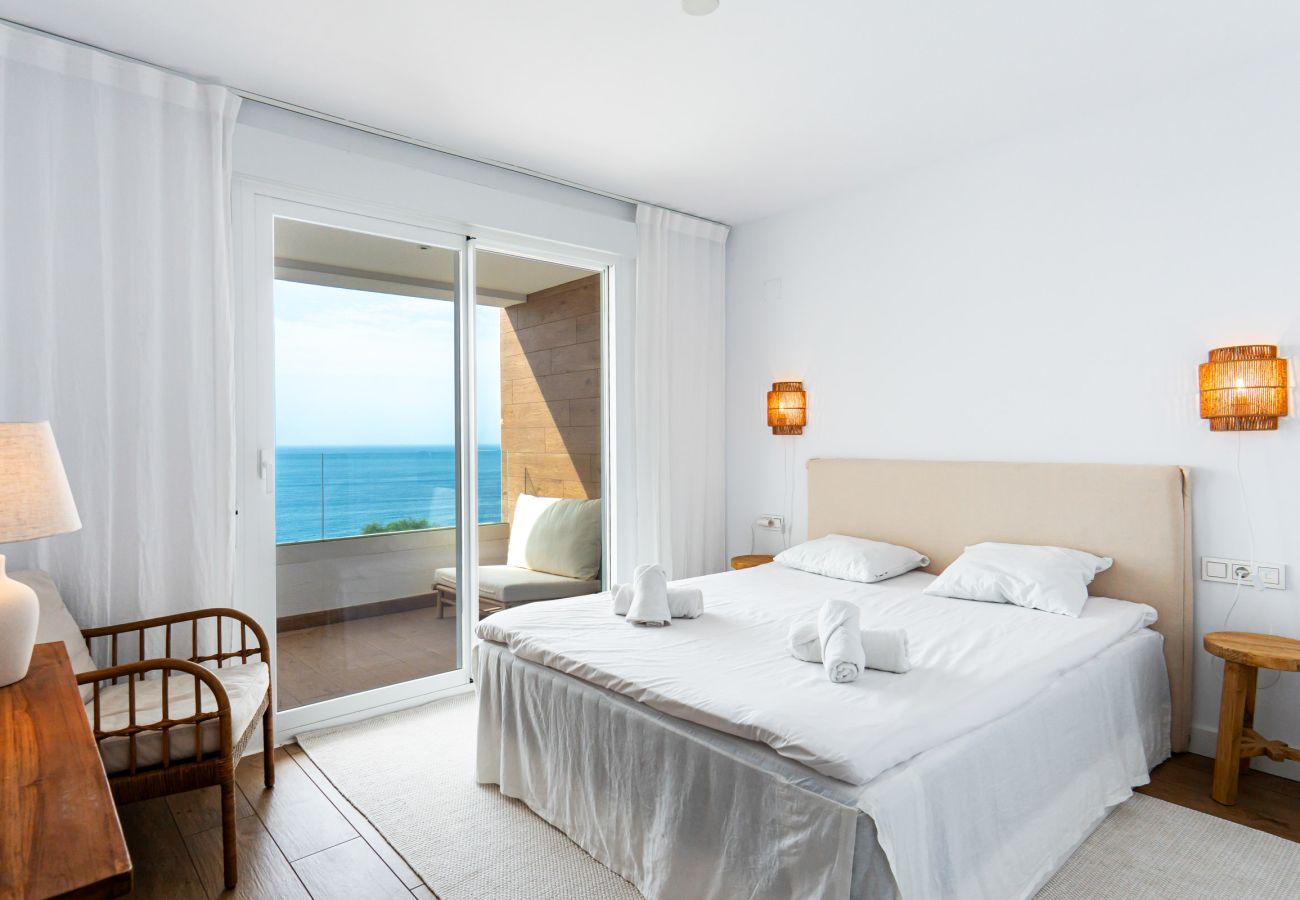 Hoofdslaapkamer met een queensize bed en uitzicht op zee in Isea Calaceite