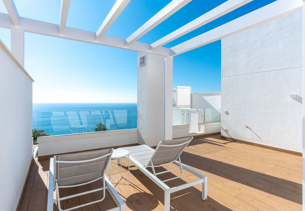 Privézonneterras met ligstoelen en een panoramisch uitzicht op zee in Isea Calaceite